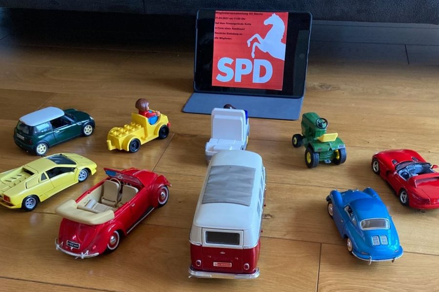 Mehrere Autos stehen vor einer Leinwand