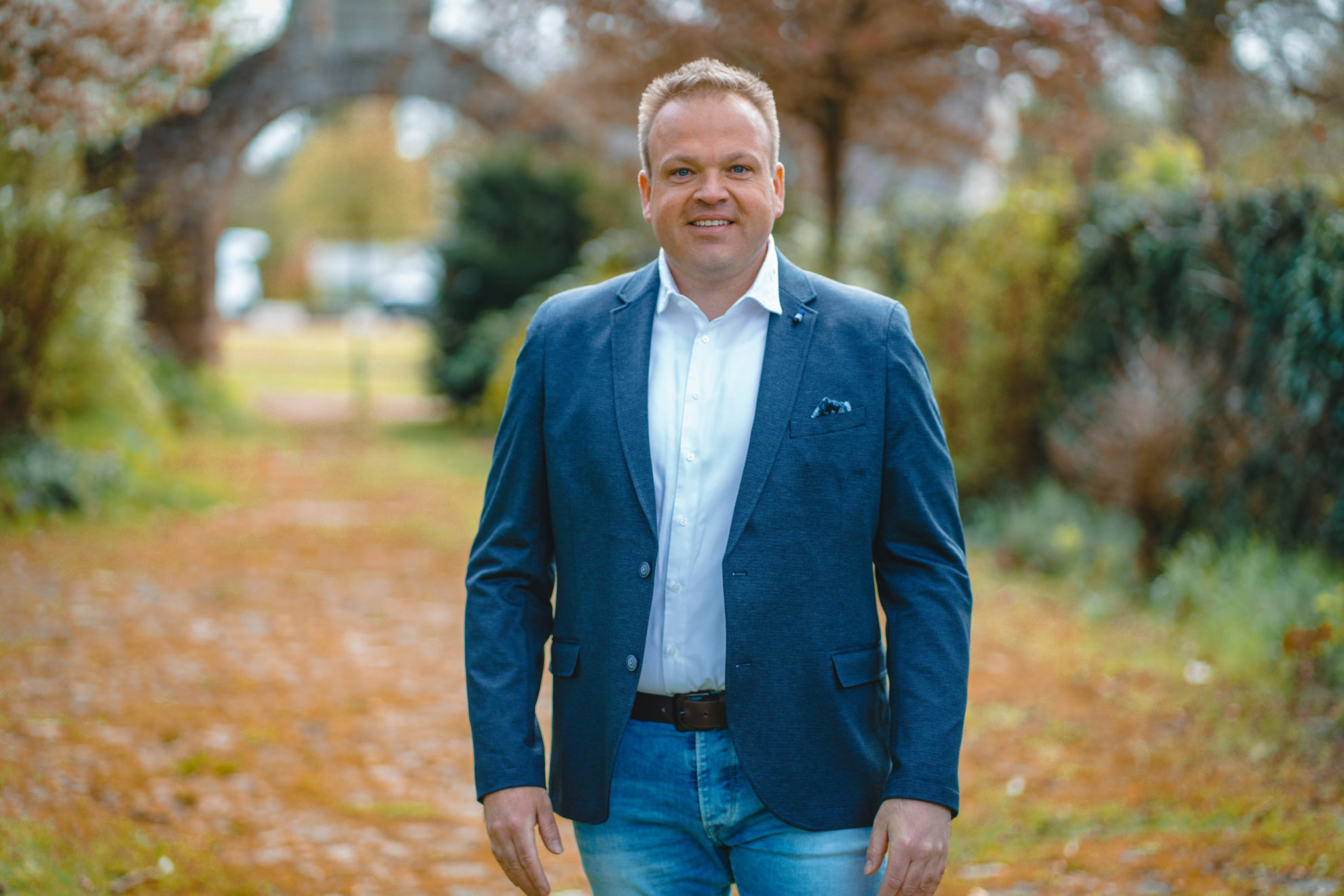 Chrsitian steht vor einem Tor. Im Hintergrung ist grüne Landschaft zu sehen.